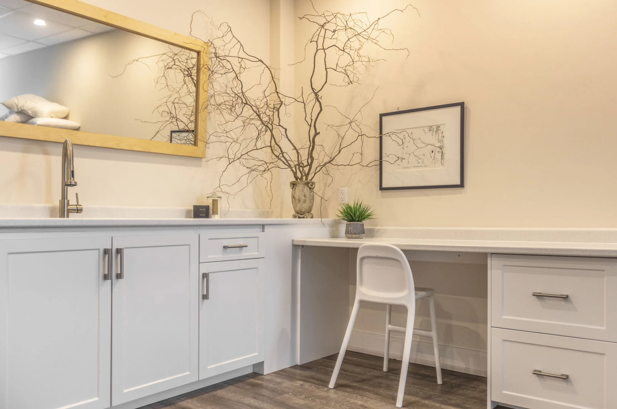 A white cupboard reception area with a white chair and area with sink