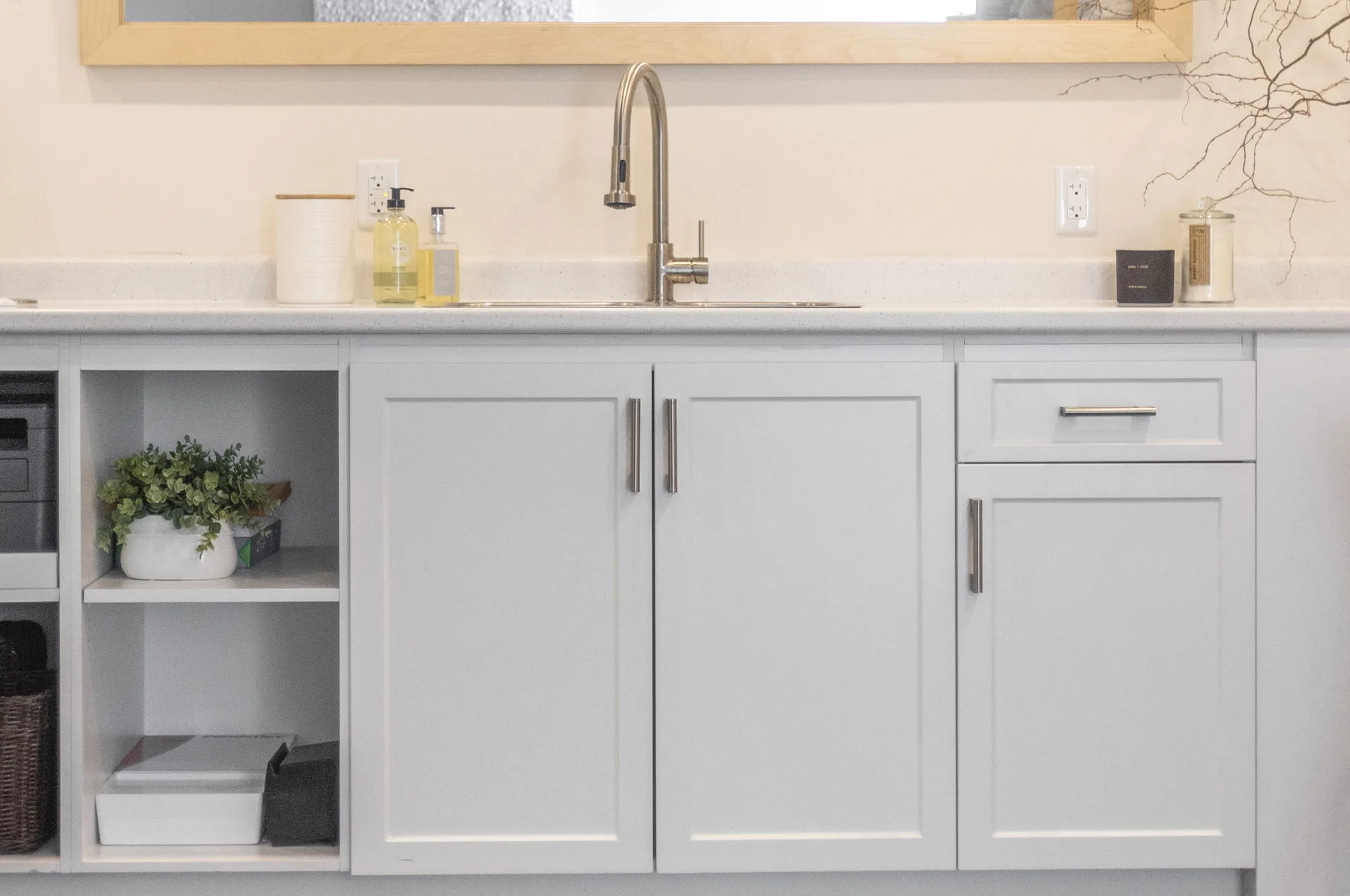 Close up of a white lower cupboards with silver hardware bathroom vanity with open shelving