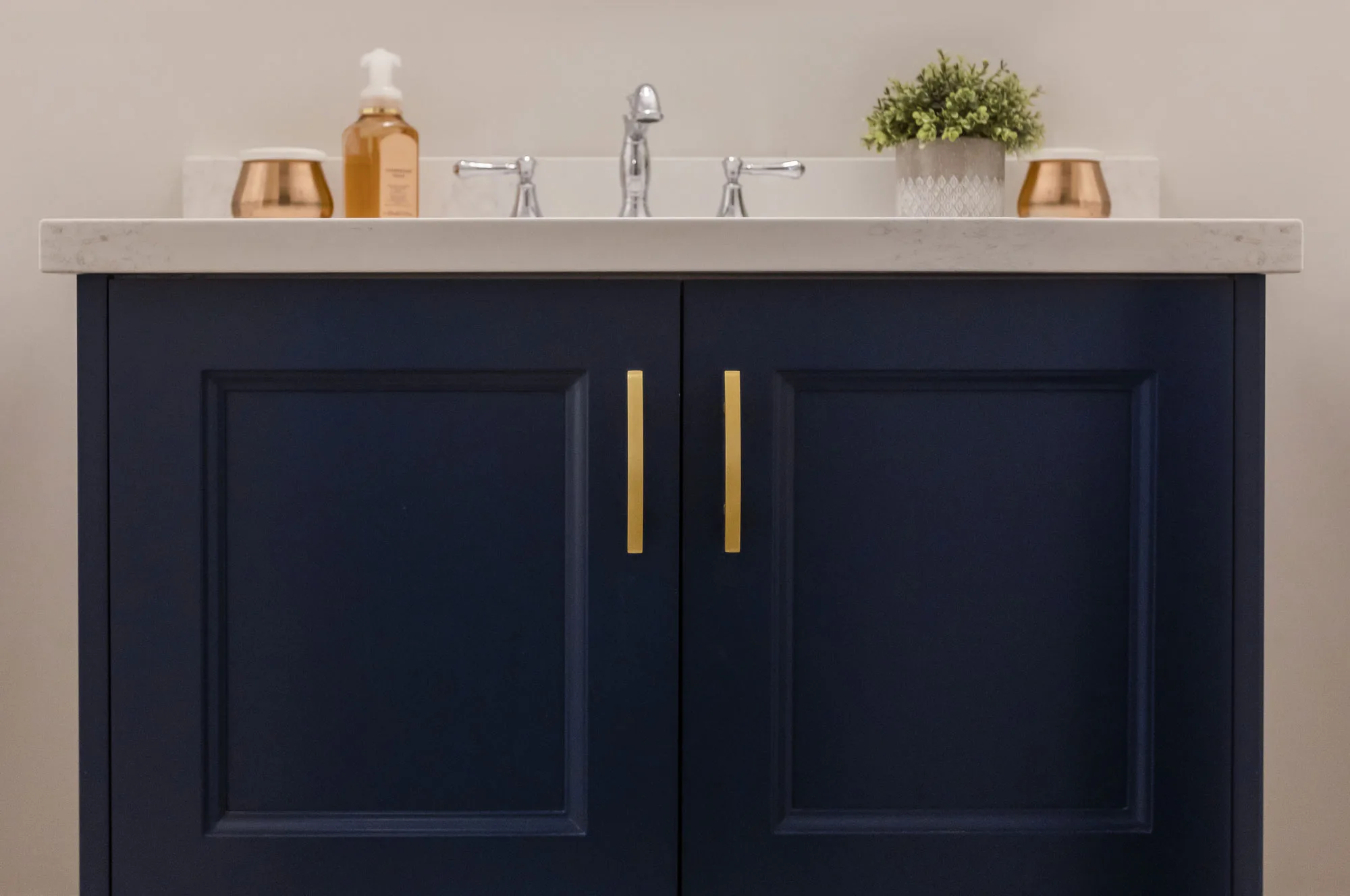 Close up of a dark navy with gold hardware bathroom vanity
