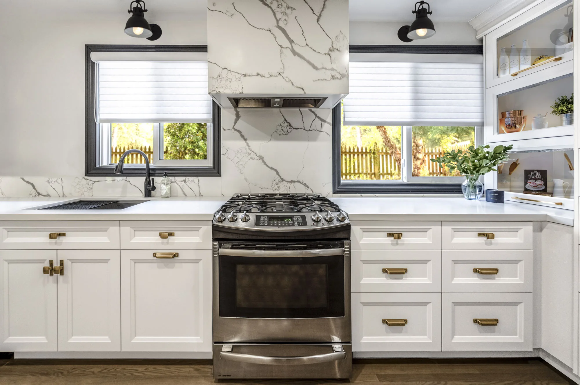 Beautiful off-white kitchen with gold handles with stainless steel oven