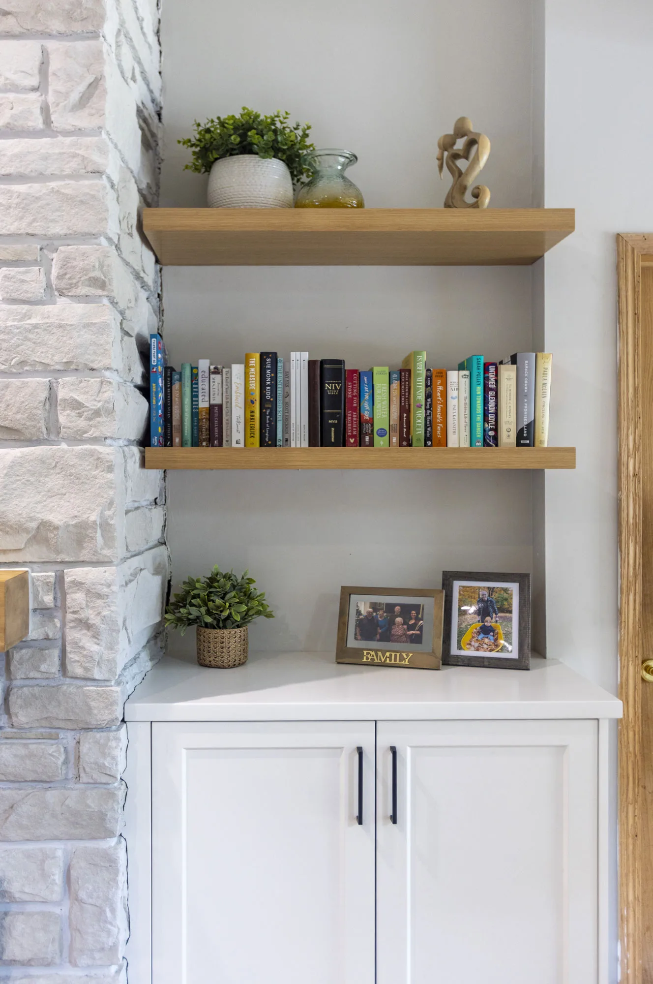 Close up of wooden shelving and white cabinet with silver hardware.