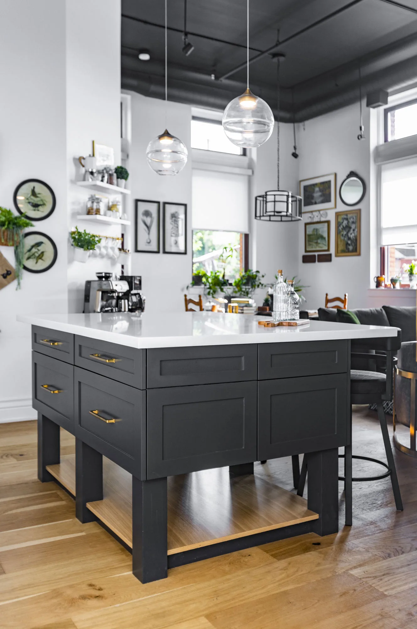 A dark grey kitchen island with a white top and gold handles