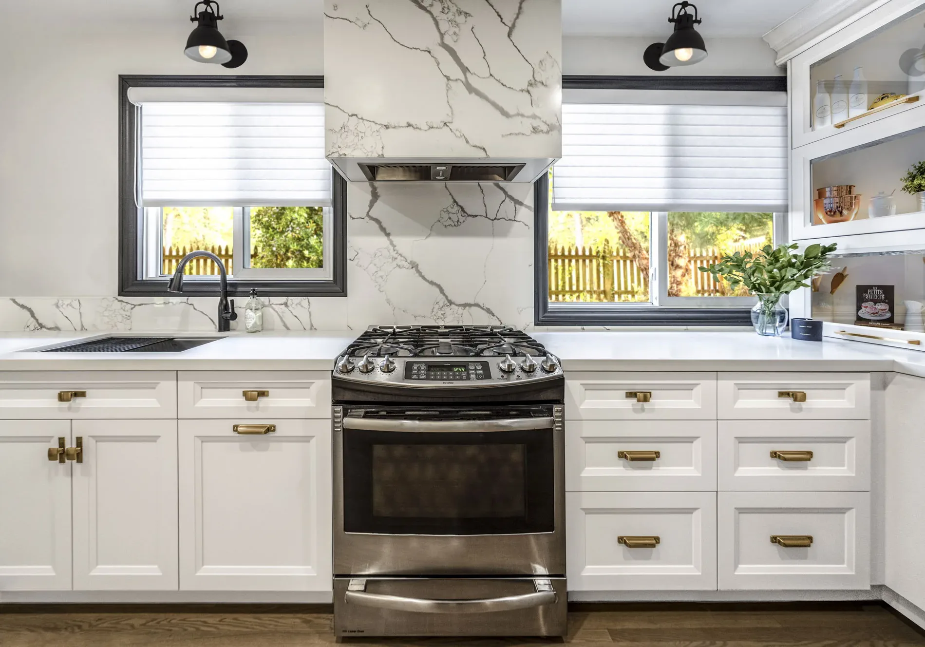 Beautiful off-white kitchen with gold handles with stainless steel oven